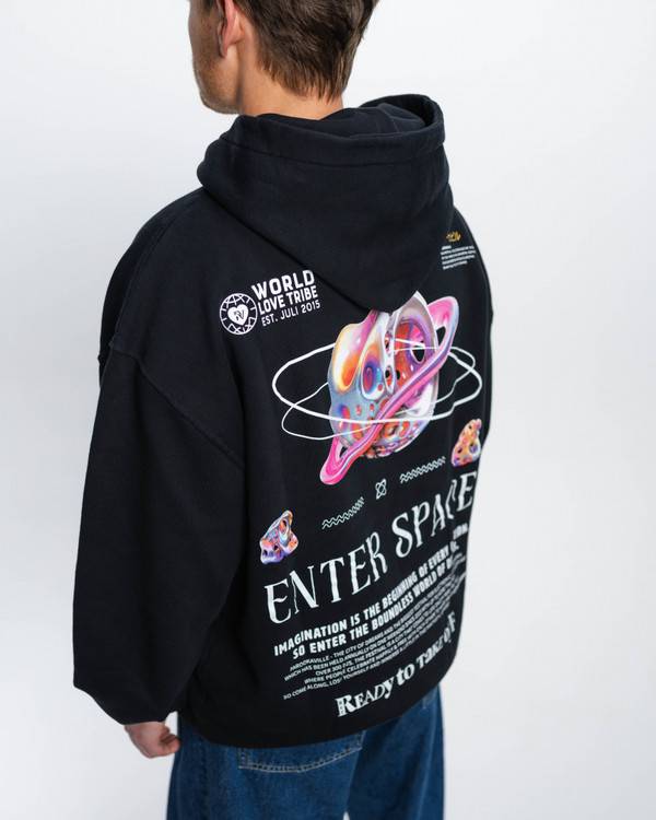 (DE) Ein Mann trägt einen schwarzen Hoodies mit Backprint aus bunte Planeten, Text in weißer Schrift und darüber einem großen Schriftzug "ENTER SPACE". (EN) A man is wearing a black hoodie with a back print of colourful planets, text in white lettering and a large lettering ‘ENTER SPACE’ above it.