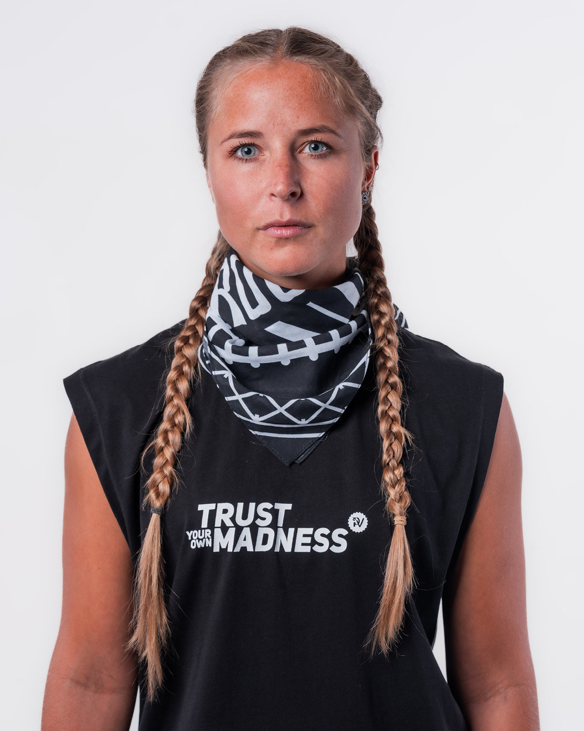 (DE) Eine Frau trägt die Bandana mit Rails Motiv um den Hals und dazu das schwarze MuskelShirt "TRUST YOUR OWN MADNESS". (EN) A woman wears the bandana with rails motif around her neck and the black muscle shirt ‘TRUST YOUR OWN MADNESS’.