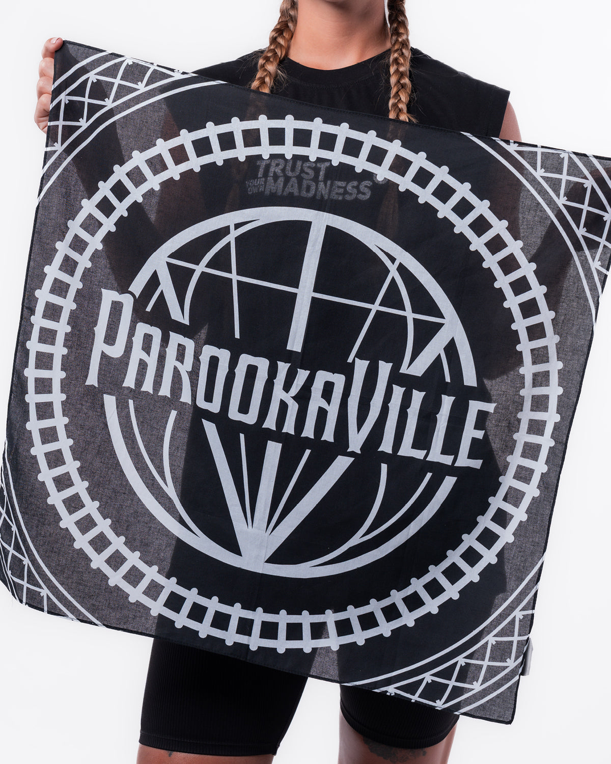 (DE) Man sieht eine schwarze Bandana mit der weißen PAROOKAVILLE Schrift umkreist von einem Schienenmuster. (EN) You can see a black bandana with the white PAROOKAVILLE lettering encircled by a rail pattern.