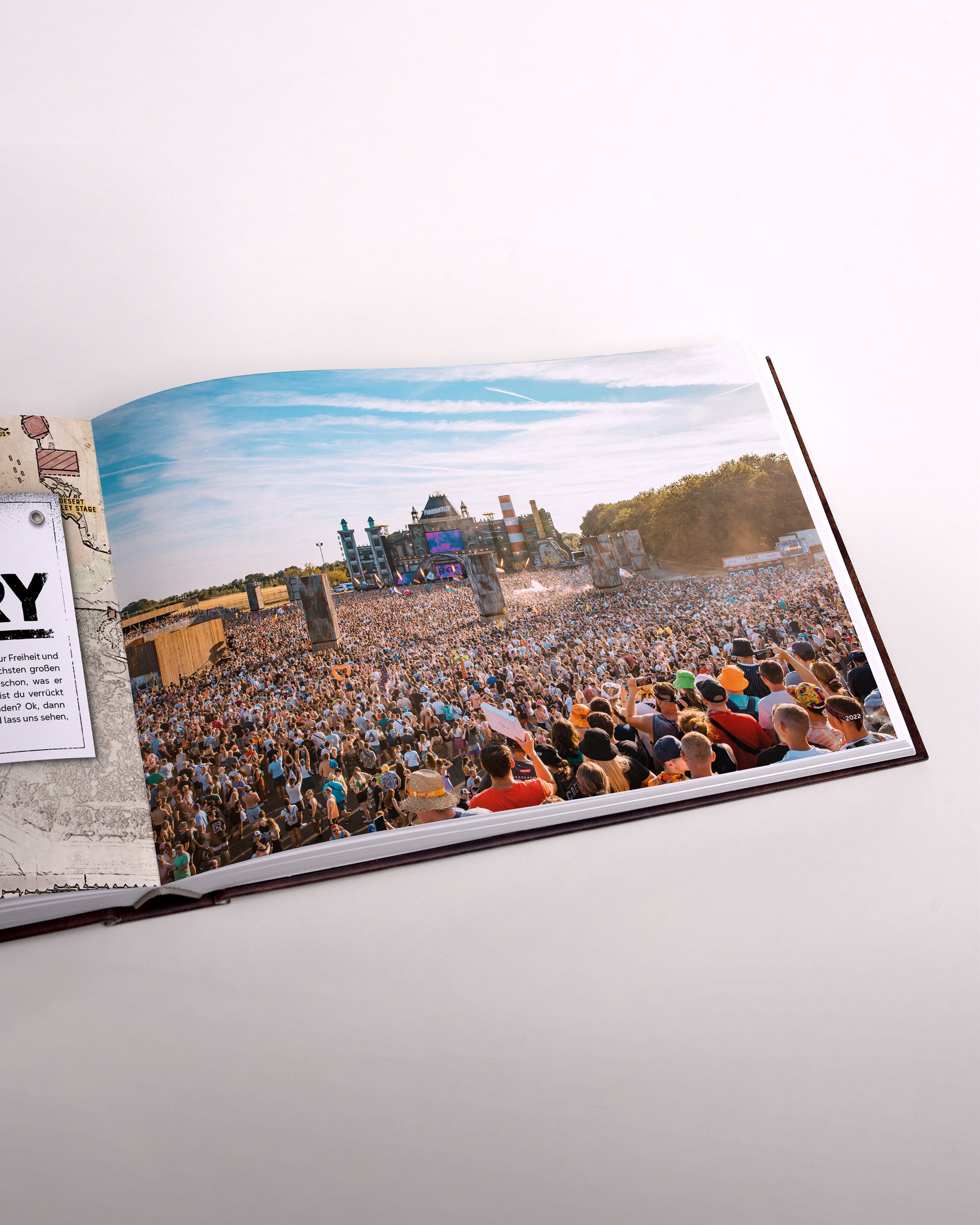 Zu sehen ist eine Seite des Buches im senkrecht-länglichen Format. Die Seite zeigt die voll besuchte New Bills Factory 2025 als Vogelperspektive in Form einer Draufsicht.