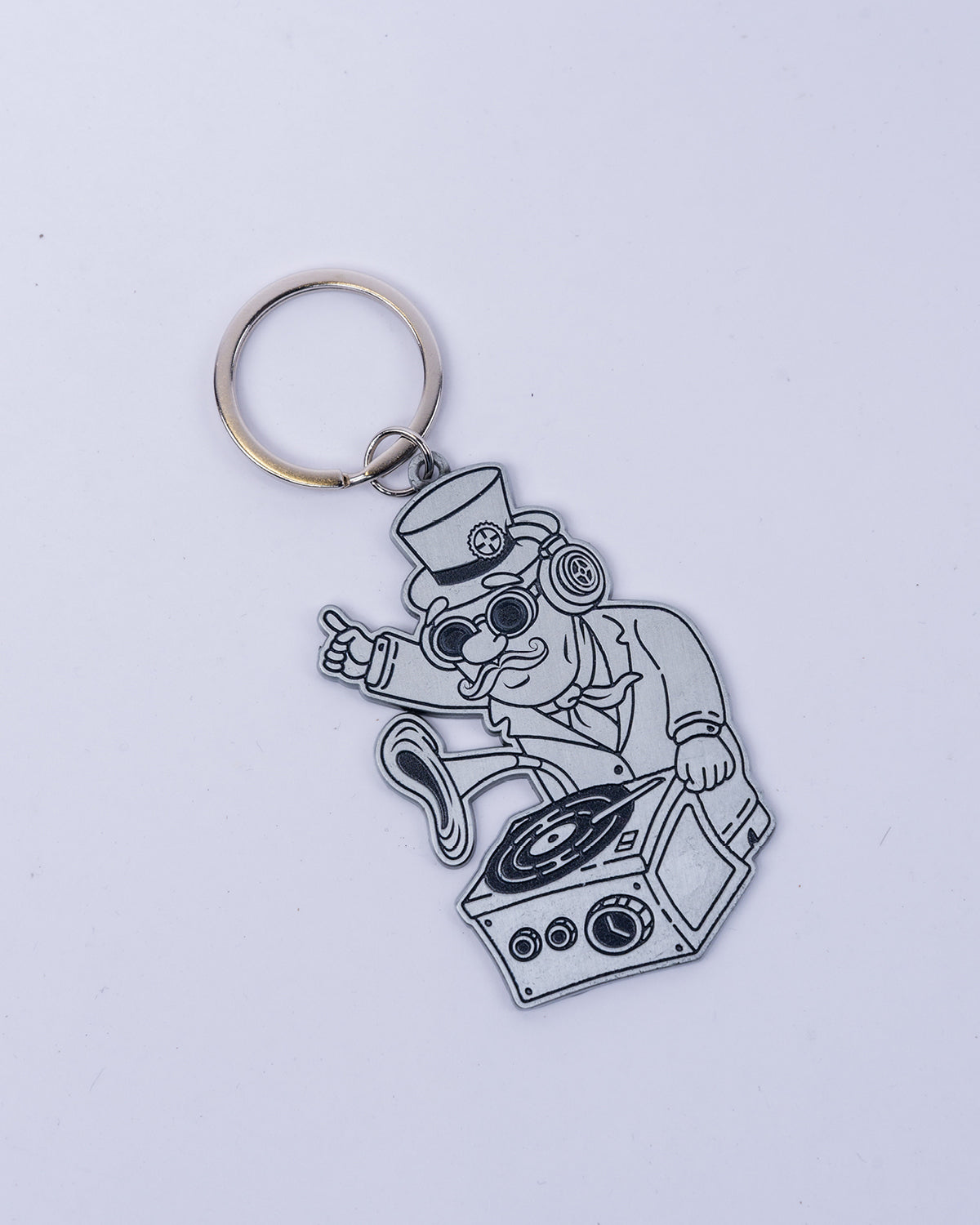 Der silberne DJ-Bill-Schlüsselanhänger zeigt Bill Parooka als DJ mit Zylinder, Brille und Kopfhörern am Grammophon-Mischpult, befestigt an einem Metall-Schlüsselring.