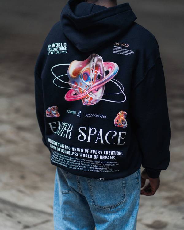 (DE) Ein Mann trägt einen schwarzen Hoodies mit Backprint aus  bunte Planeten,  Text in weißer Schrift und darüber einem großen Schriftzug "ENTER SPACE". (EN) A man is wearing a black hoodie with a back print of colourful planets, text in white lettering and a large lettering ‘ENTER SPACE’ above it.
