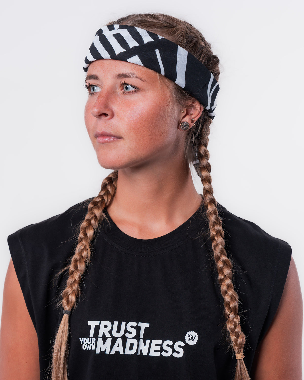 (DE) Eine Frau trägt die Rails Bandana um ihren Kopf gebunden. Dazu trägt sie das schwarze Muskel Shirt "TRUST YOUR OWN MADNESS". (EN) A woman is wearing the Rails bandana tied around her head. She also wears the black muscle shirt "TRUST YOUR OWN MADNESS".